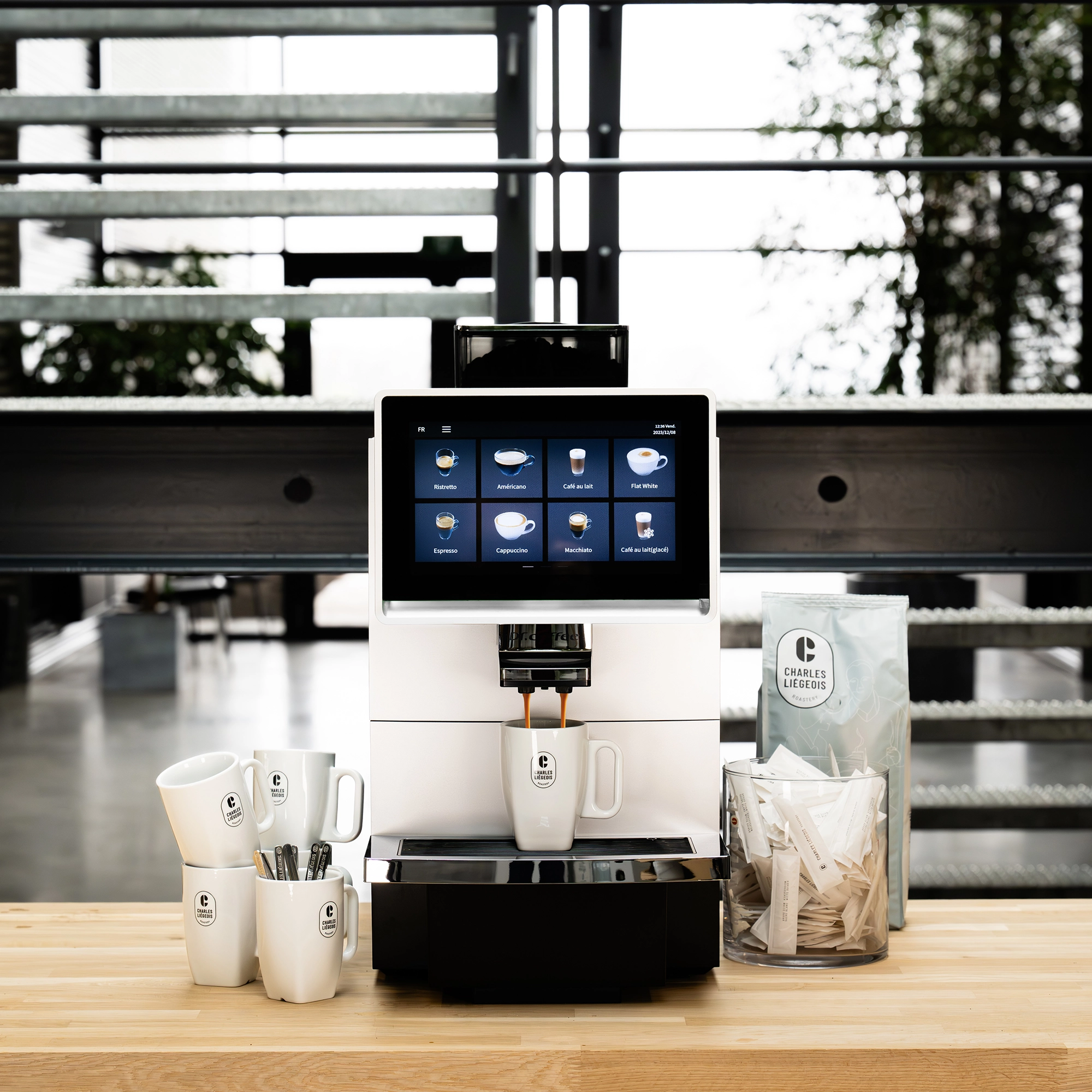 Machine &agrave; caf&eacute; professionnelle Dr Coffee F08 install&eacute;e sur un comptoir d'entreprise, entour&eacute;e de mugs, de lait et de sucre, pour des pauses caf&eacute; pratiques et conviviales au bureau.