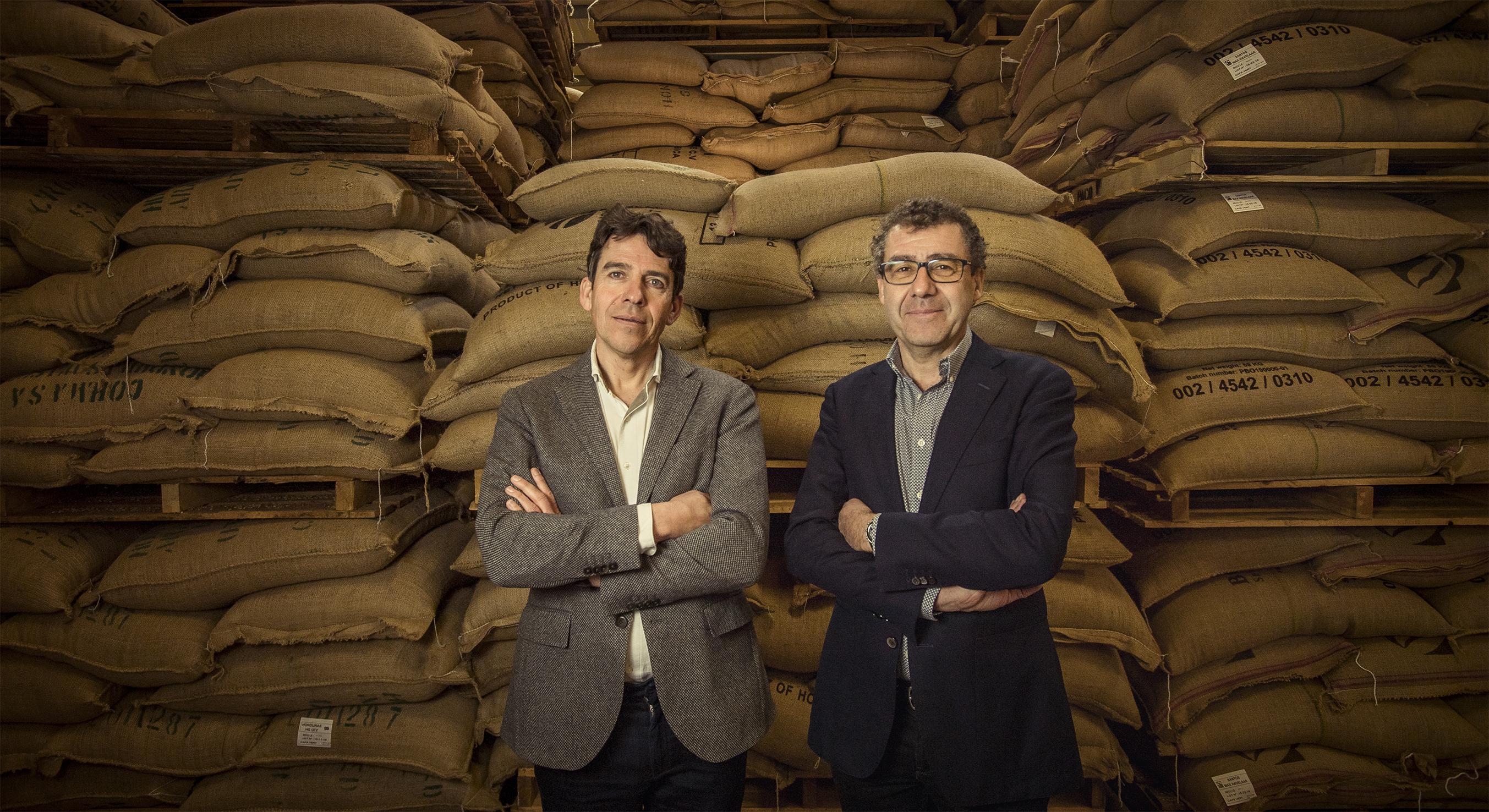 Michel and Benoit Liégeois in front of the bags of green coffee.